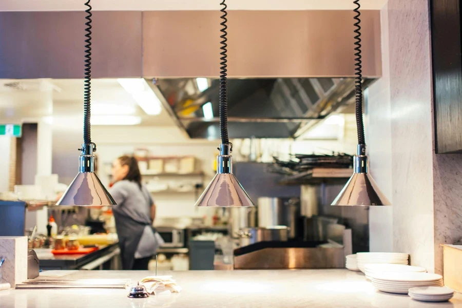 Restaurant kitchen with faceless woman behind serving counter