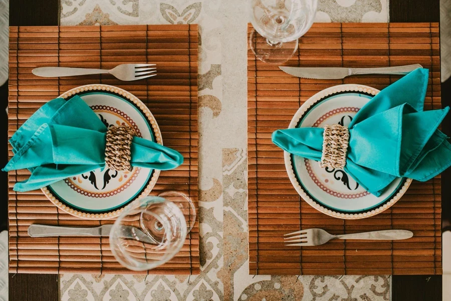 Served banquet table with ornamental plates and blue napkins