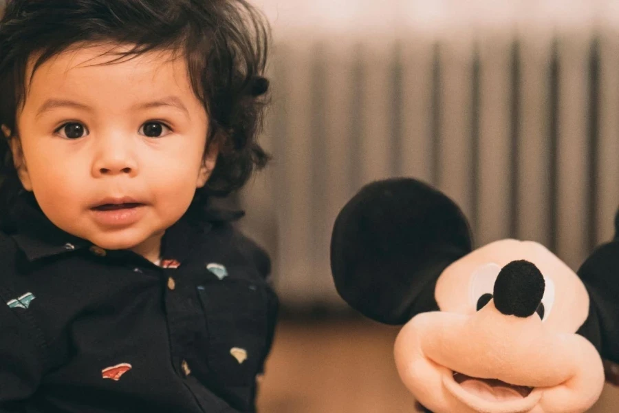 Sitting Child Playing Mickey Mouse Plush Toy