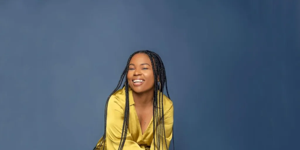 Smiling woman in yellow with crochet braids