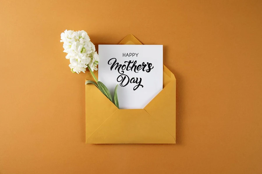 Top view of envelope beside rustic scissors and flowers