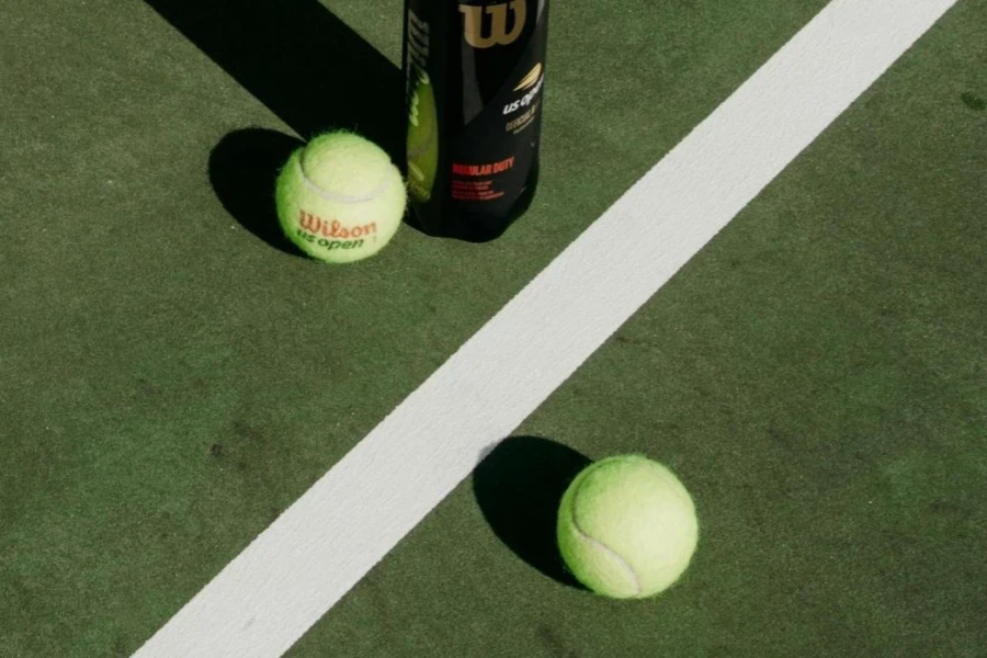 Two Wilson US Open tennis balls on a hard court