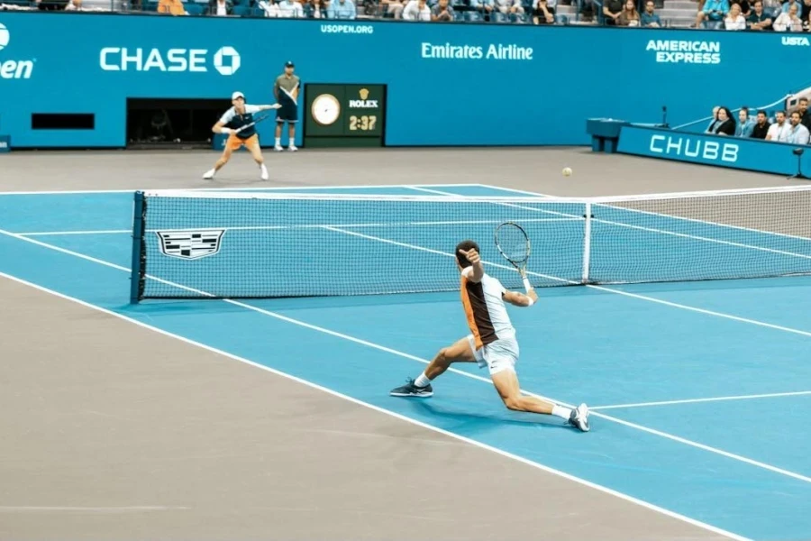 Two men playing on a blue tennis court