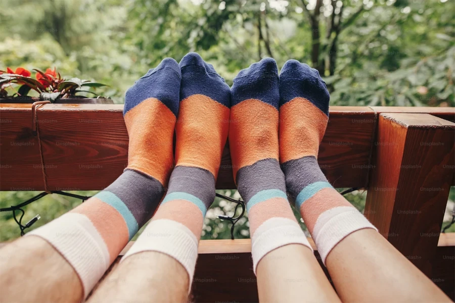 Two pairs of colorful =socks worn by hikers