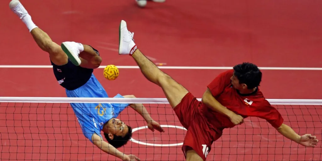 Two people engaged in a sepak takraw game