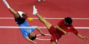 Two people engaged in a sepak takraw game
