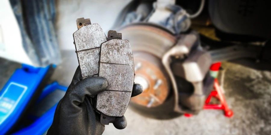 Used car brake pads in the hands of a mechanic