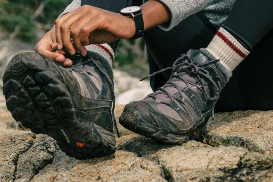 Woman adjusting her hiking shoe with thick soles