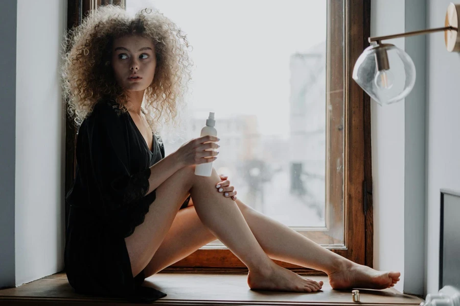 Woman in Black Dress Sitting on Brown Wooden Window