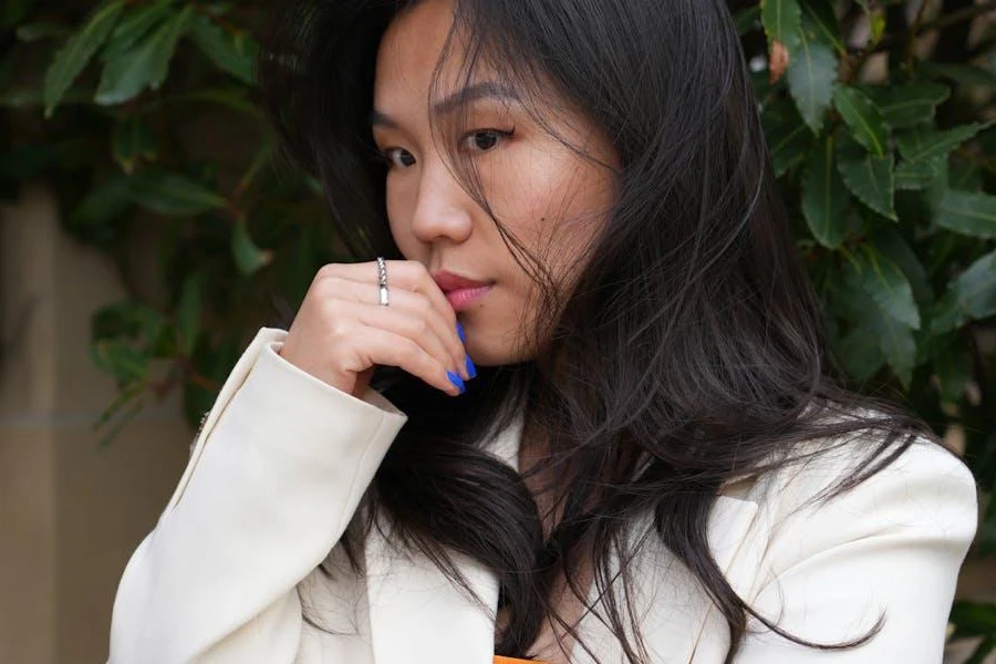 Woman in a white jacket with wistful expression