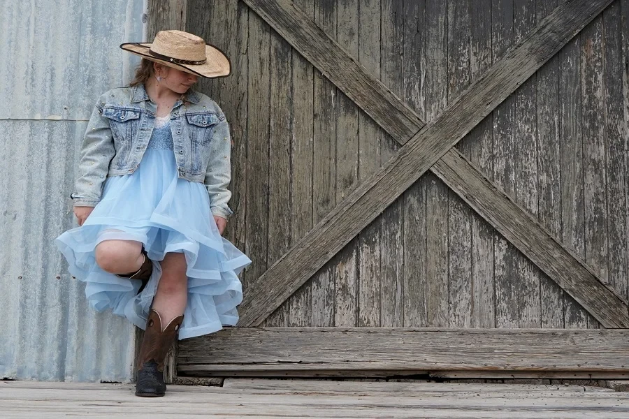 Woman in denim barn coat, light-blue dress and mid-calf boots