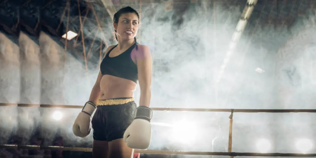 Woman standing in boxing ring wearing white mouthguard