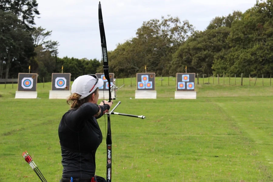 Woman using release aid on bow to line up target