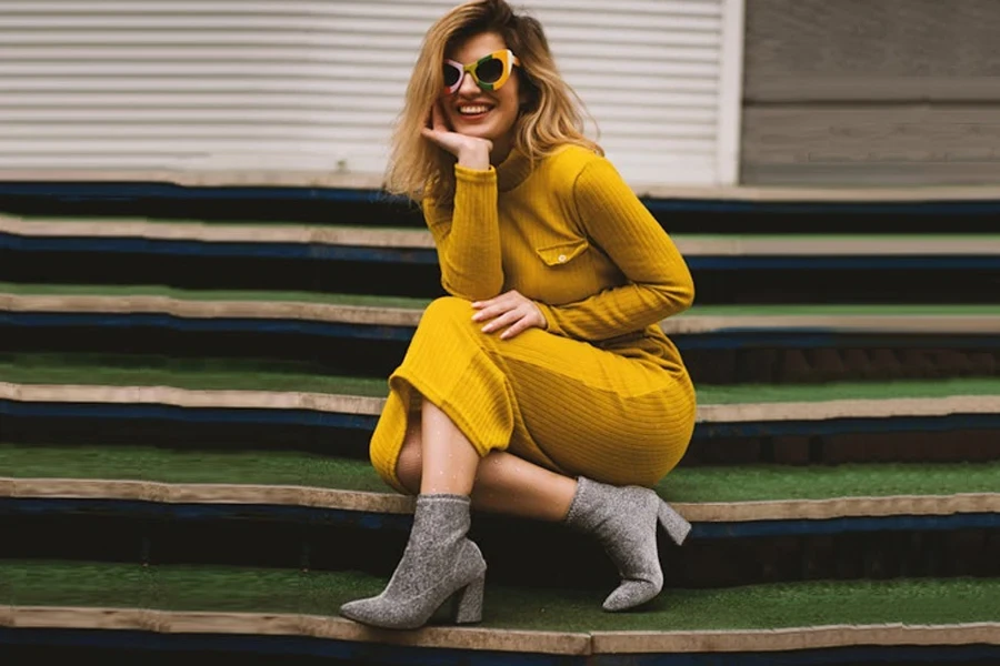 Woman wearing mustard-colored ribbed dress and gray ankle boots