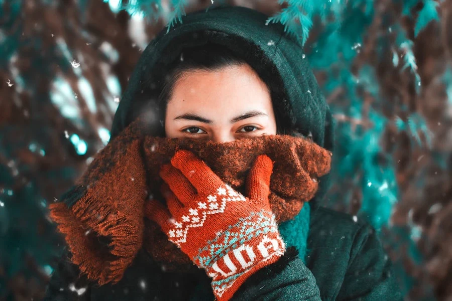 Woman wearing red full-finger winter gloves with intricate patterns