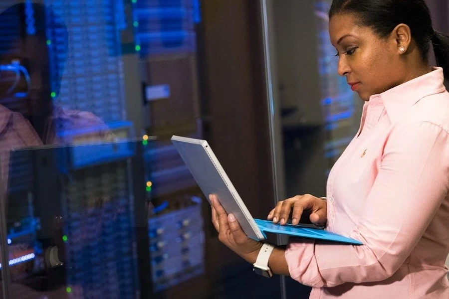 Woman working on a laptop while next to servers