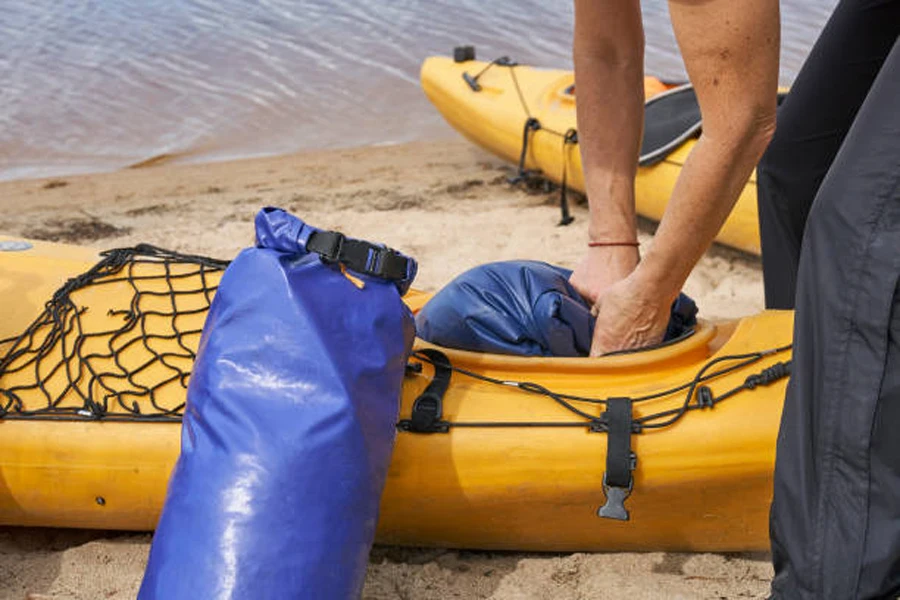 Yellow kayak with blue kayaking dry bags being stored inside