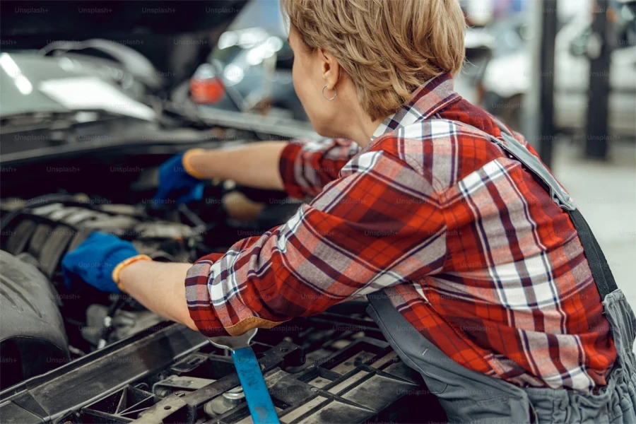 back view of a female worker leaning over a motor