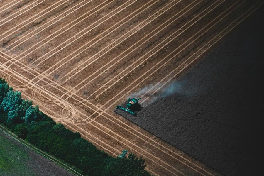 combine harvester at work showing tracks across a field