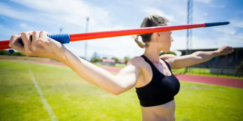 Female athlete preparing to throw red and blue javelin