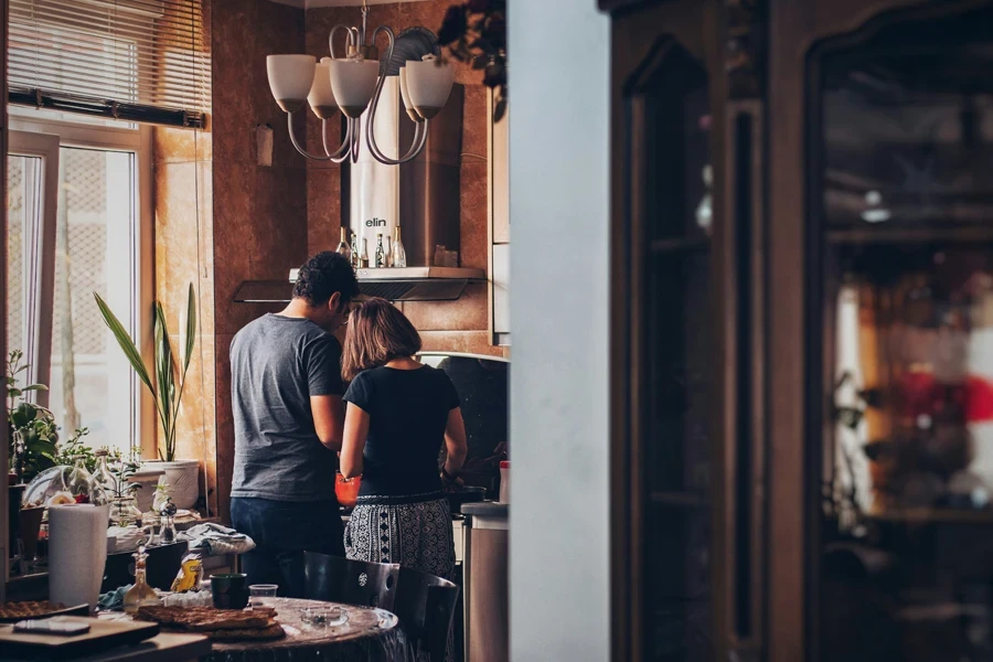 man and woman standing in front of gas range