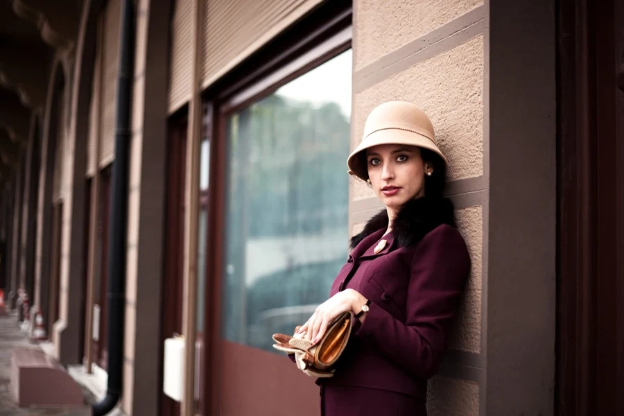 old fashioned woman posing near an odl building