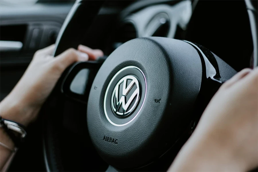 person holding black volkswagen steering wheel