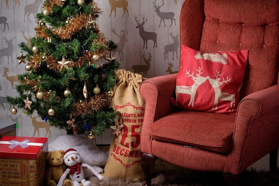 A Christmas tree with presents and a chair with cushion