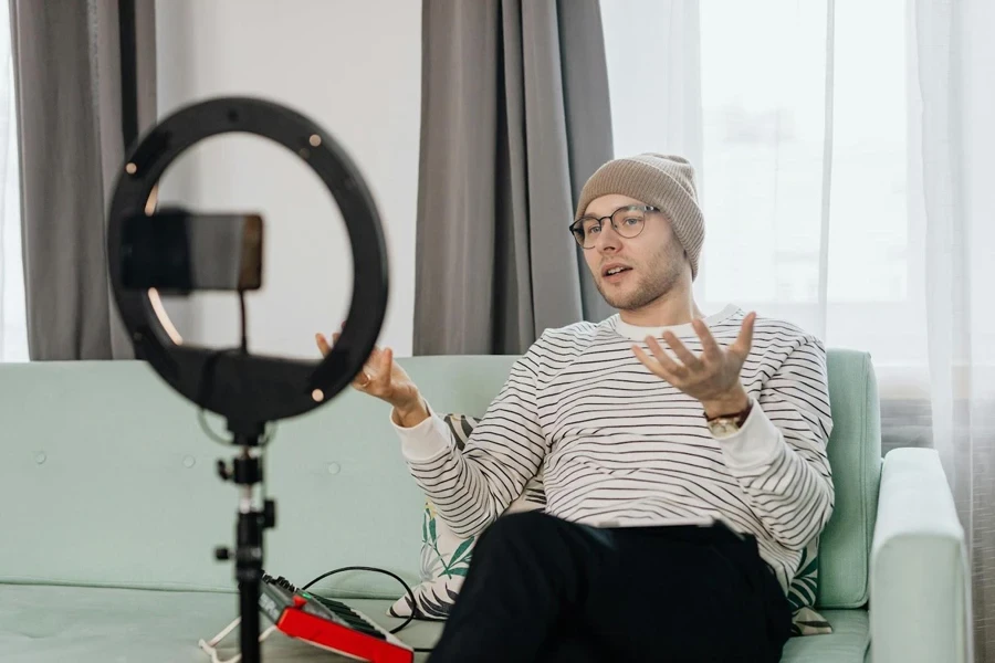 A Man Wearing White Striped Shirt and Brown Beanie Making a Vlog