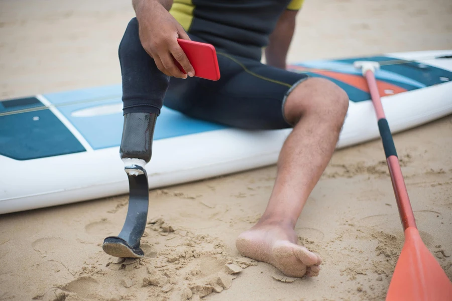 A Man with a Prosthetic Leg Sitting on a Paddle Board