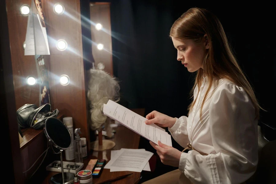 A Woman Sitting in front of the Makeup Mirror