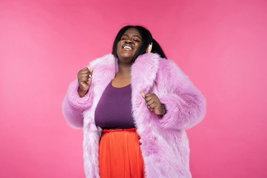 A beautiful woman posing in an XL furry coat