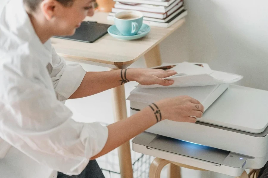 A female worker taking sheets of paper for laser printing