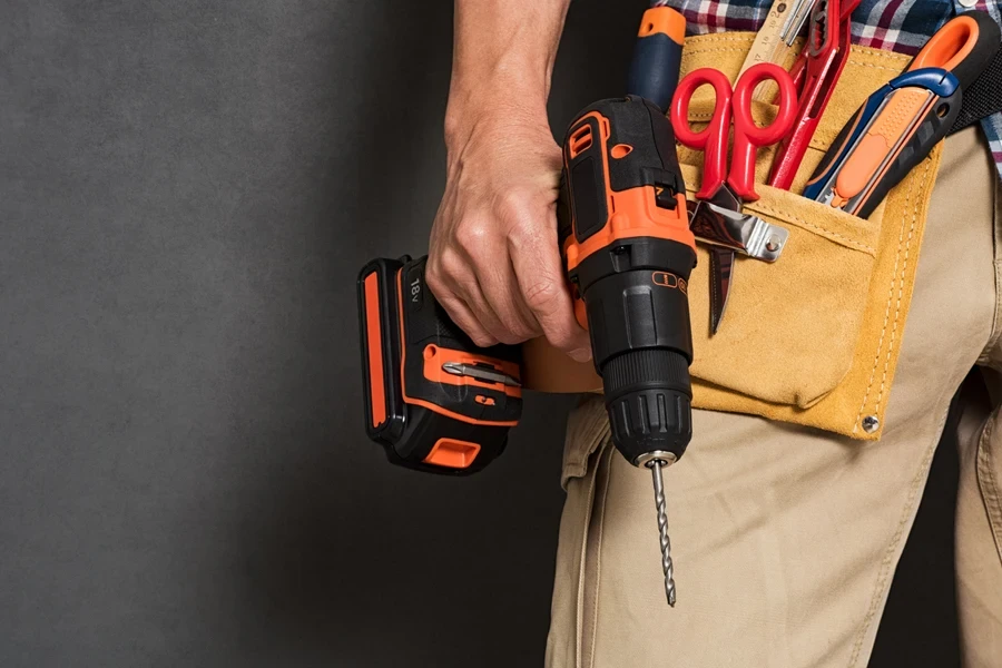 A handyman with tool belt, holding a drill machine