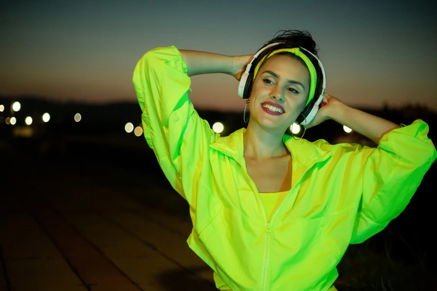 A lady in a neon jacket listening to music