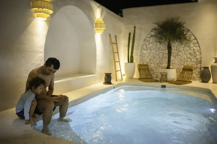 A man and boy sitting at a plunge pool