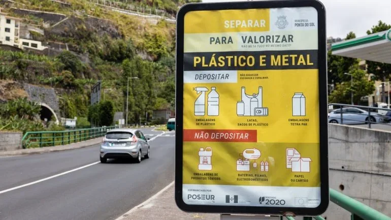 A roadside sign in Ponta do Sol, Madeira, Portugal, offers guidance on disposing of plastic and metal waste separately