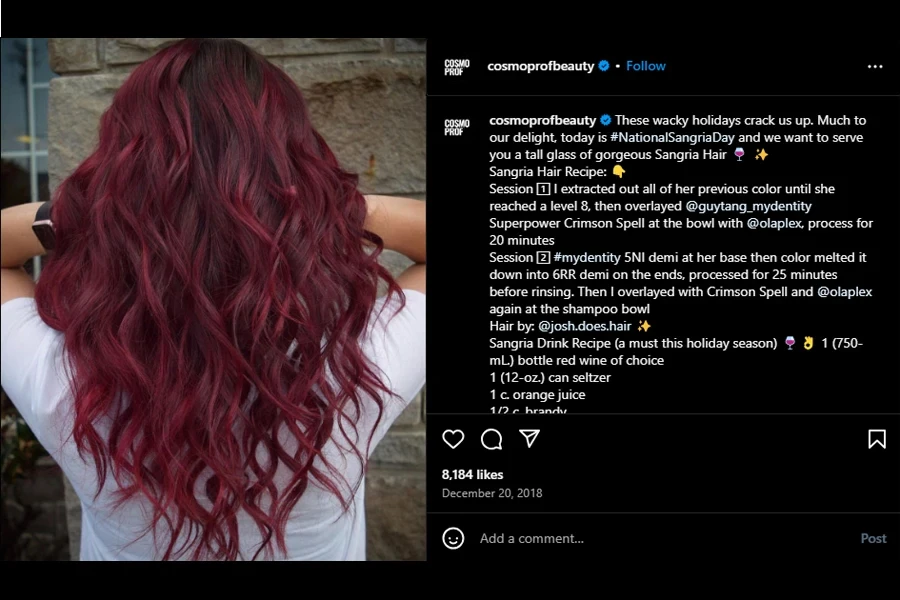 A screenshot of a woman showcasing sangria-colored hair