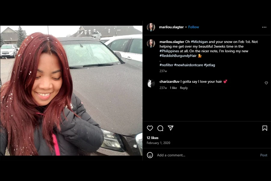 A screenshot of a woman showing her reddish burgundy hair