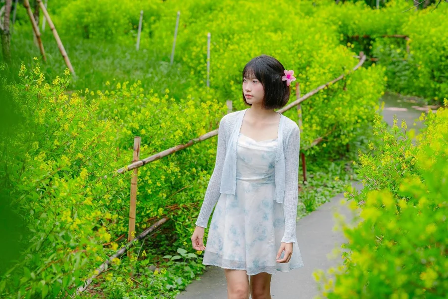 A woman in a white dress walking through a garden