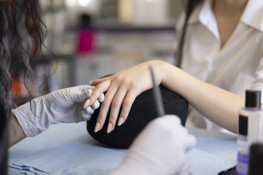 Aesthetician removing a client’s acrylic nails