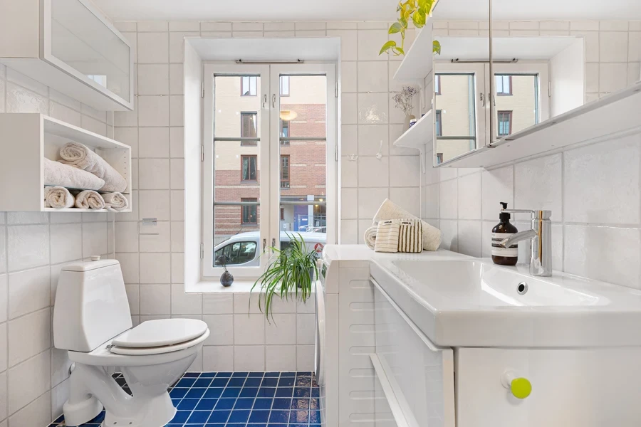 Airy white-themed bathroom with blue tiles