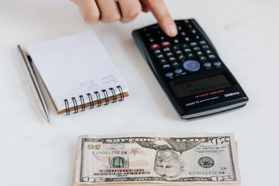 An accountant using calculator near a pile of money