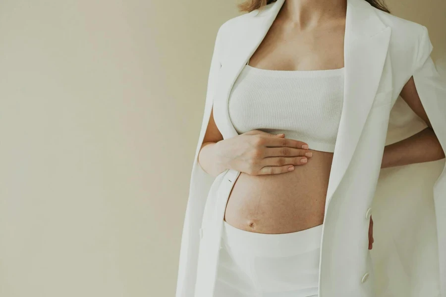 Baby Bump of a Pregnant Woman Dressed in White