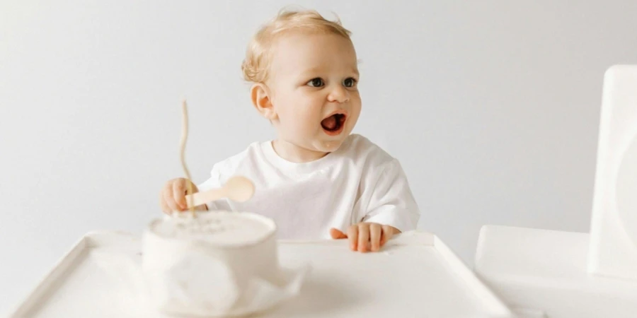 Baby Sitting in front of a Birthday Cake