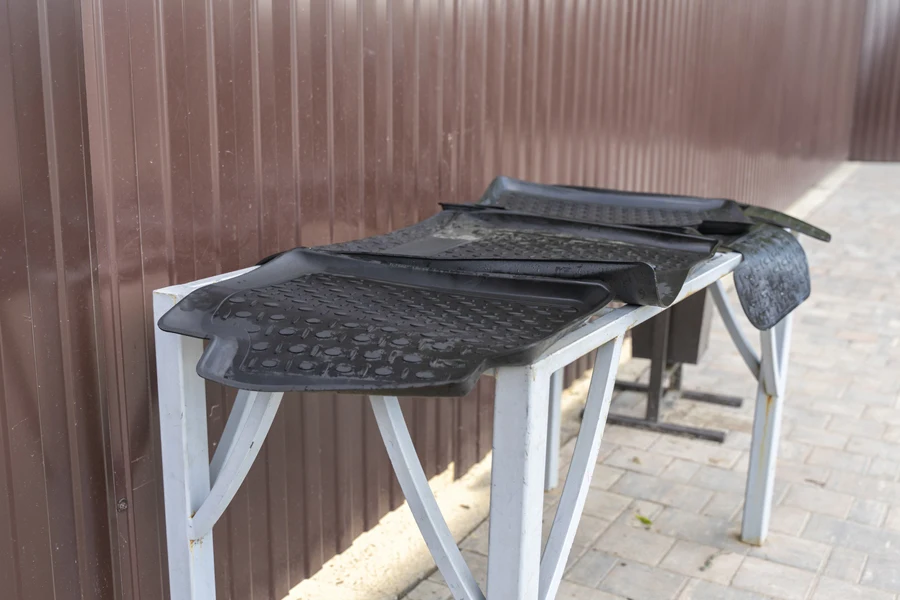 Black all-weather car floor mats on a table to dry