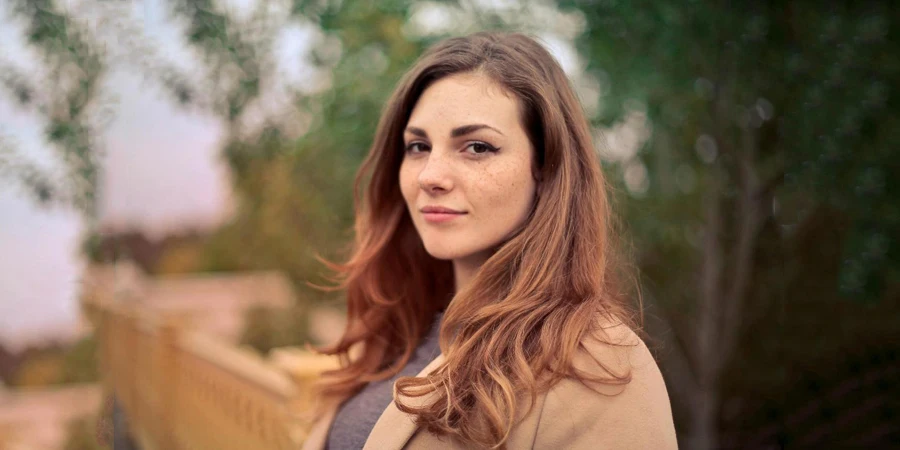 Closeup Photo of Woman With Brown Coat and Gray Top