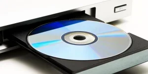 Disk drive in DVD player on a white background. Light shade.