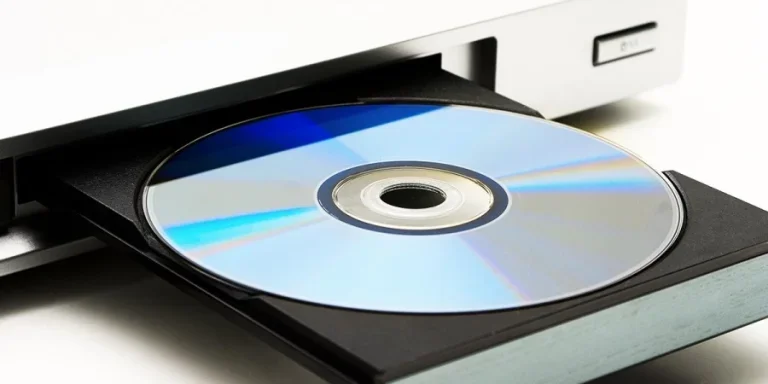 Disk drive in DVD player on a white background. Light shade.