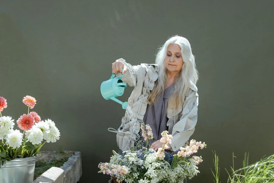 Elderly Woman Watering Flowers